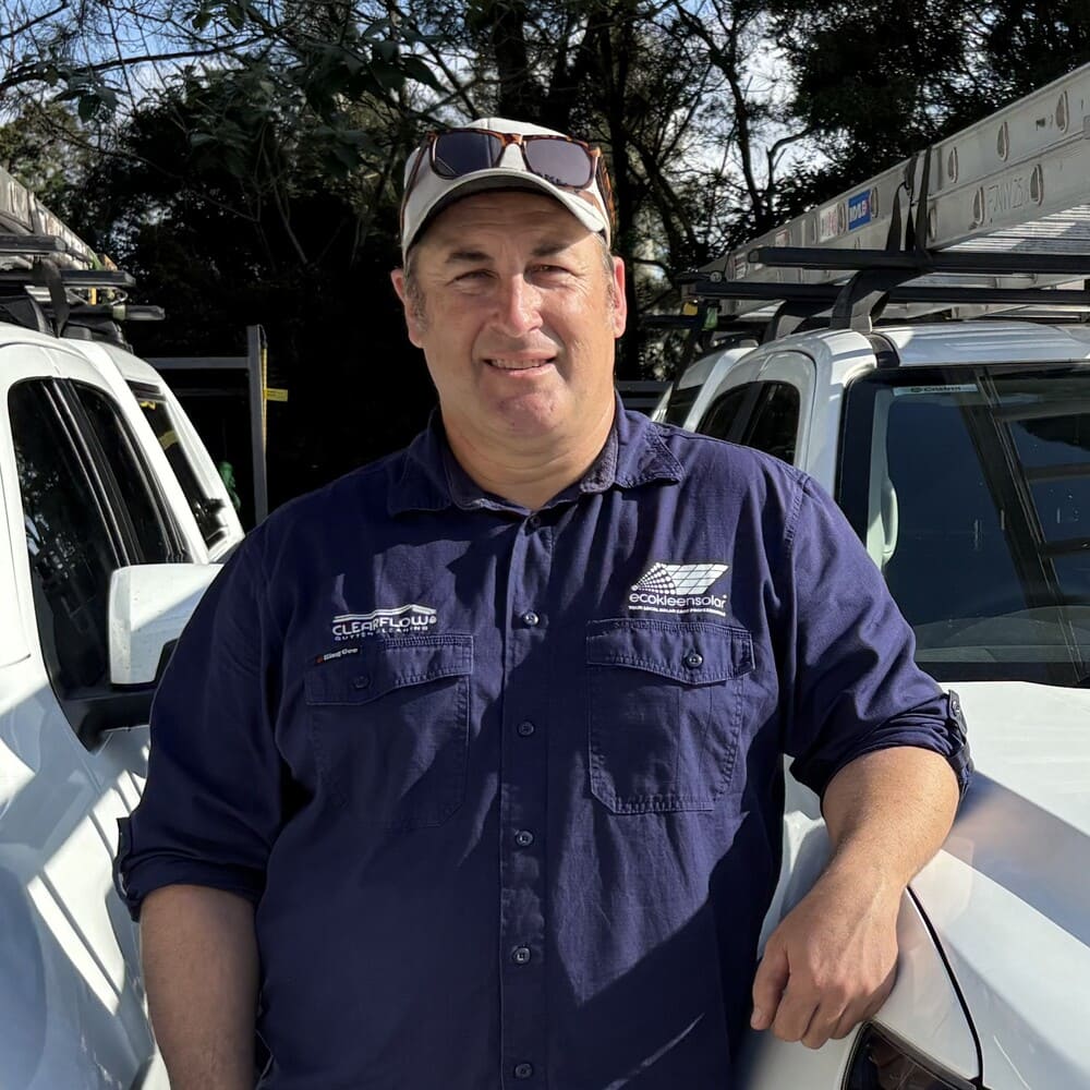 Joel owner of EcoKleen Solar standing beside work vehicle wearing branded uniform and cap